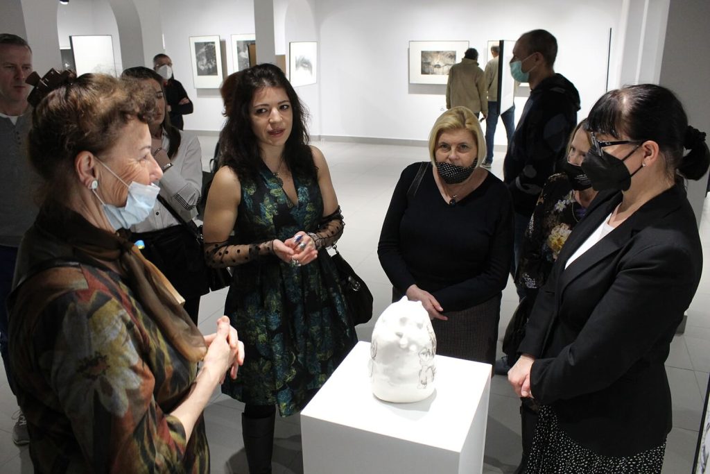 Dyskusja twórców i gości przy rzeźbie wystawionej na wystawie