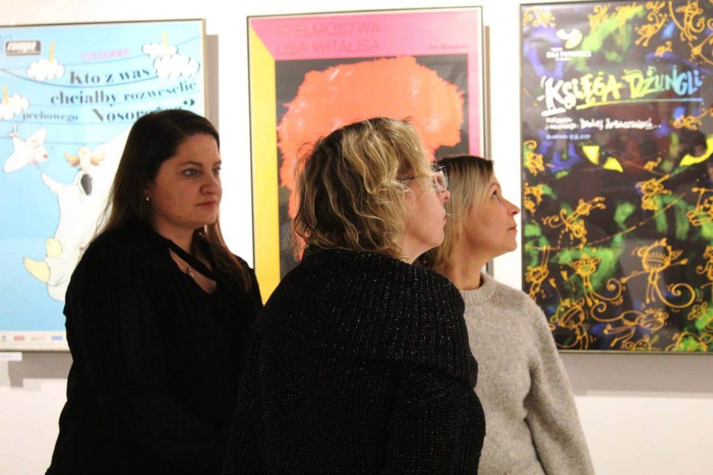 Trzy kobiety oglądają zgromadzone plakaty