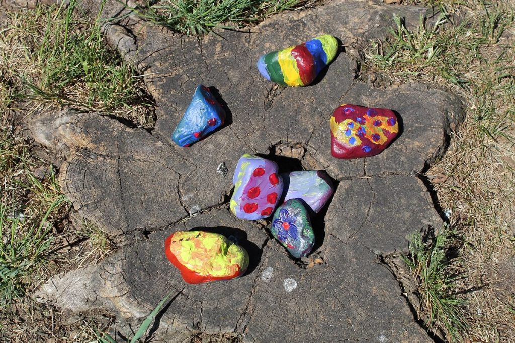 Kolorowe kamienie ułożone na ściętym pniu