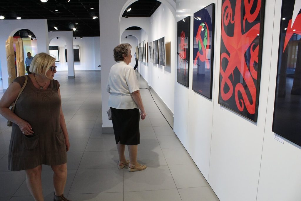 Kobiety oglądające obrazy zgromadzone na wystawie