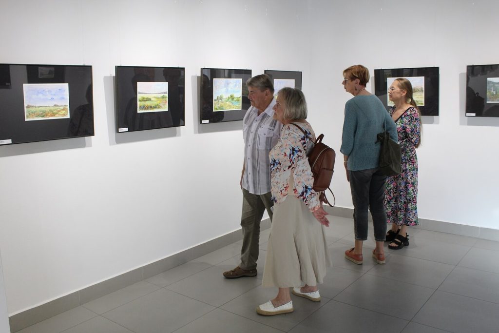 Uczestnicy wystawy oglądają obrazy Anny Wąsikiewicz