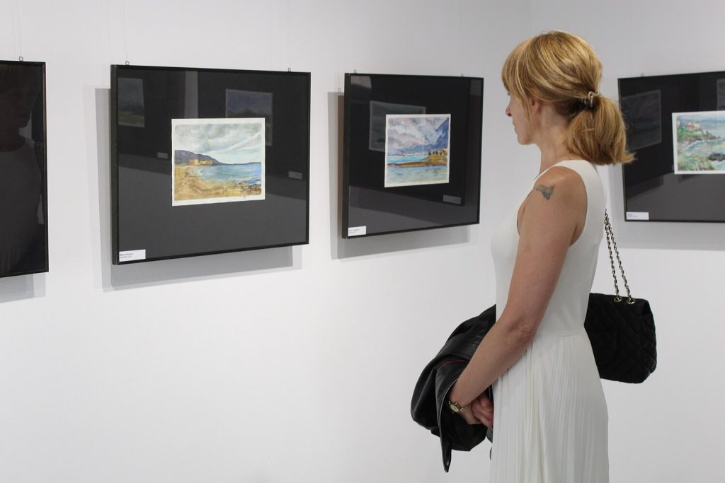 Kobieta oglądająca jeden z obrazów Anny Wąsikiewicz