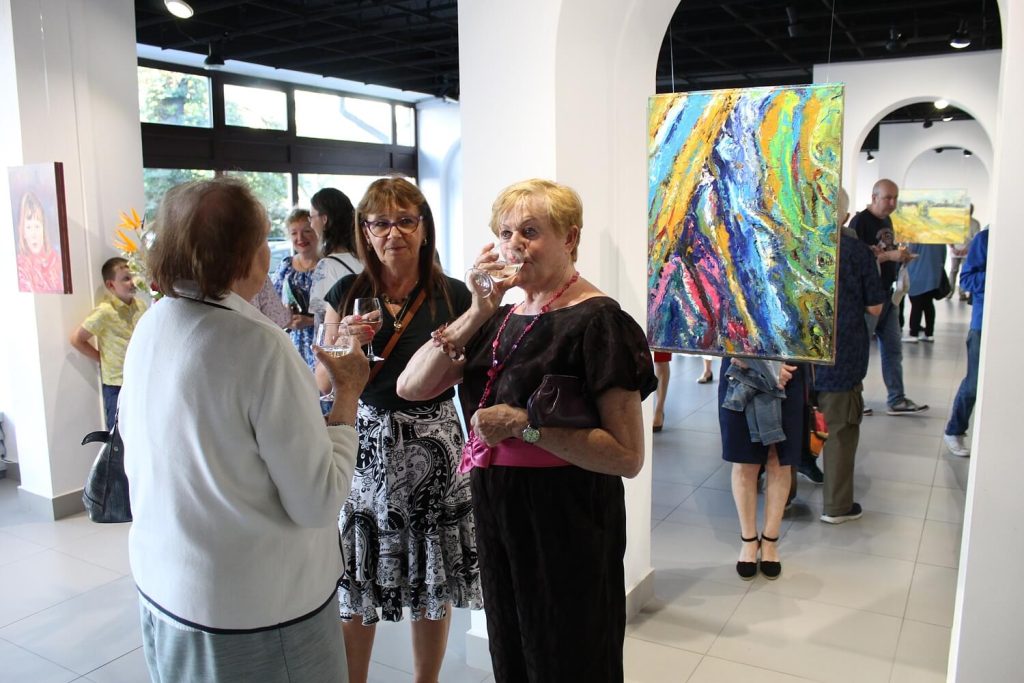 Kobiety pijące wino w trakcie wystawy dzieł Anny Wąsikiewicz