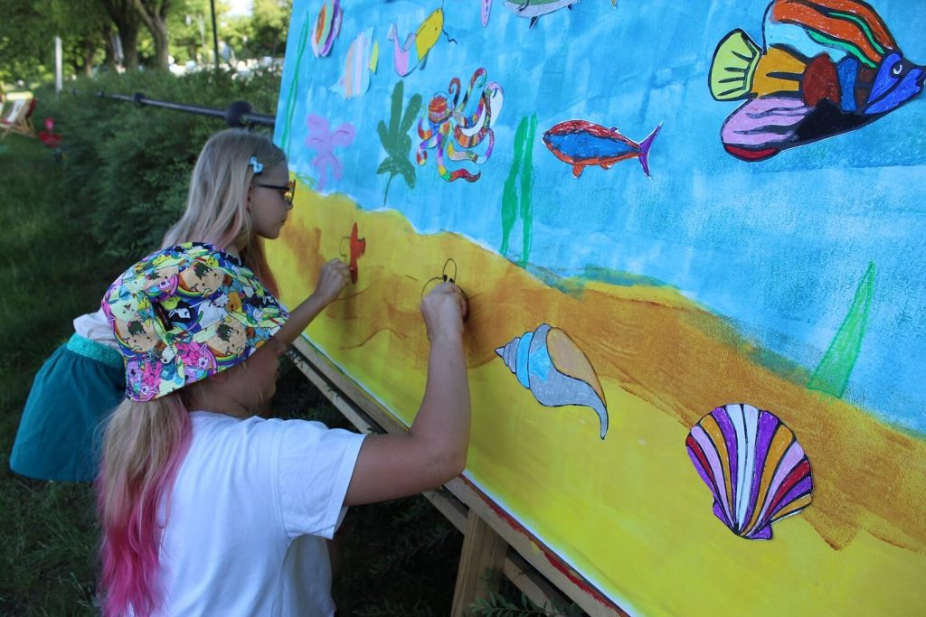 Dziewczynki rysują na tablicy z podwodnym światem