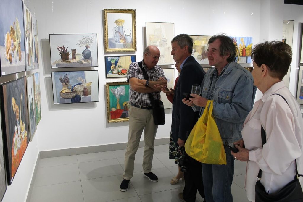 Uczestnicy wystawy oglądają zgromadzone na wystawie obrazy