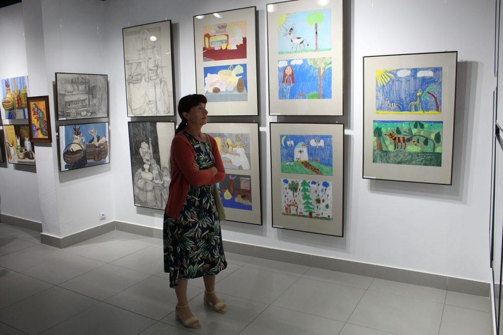 Kobieta zwiedzająca wystawę Malarstwo i rysunek z pracowni plastycznej
