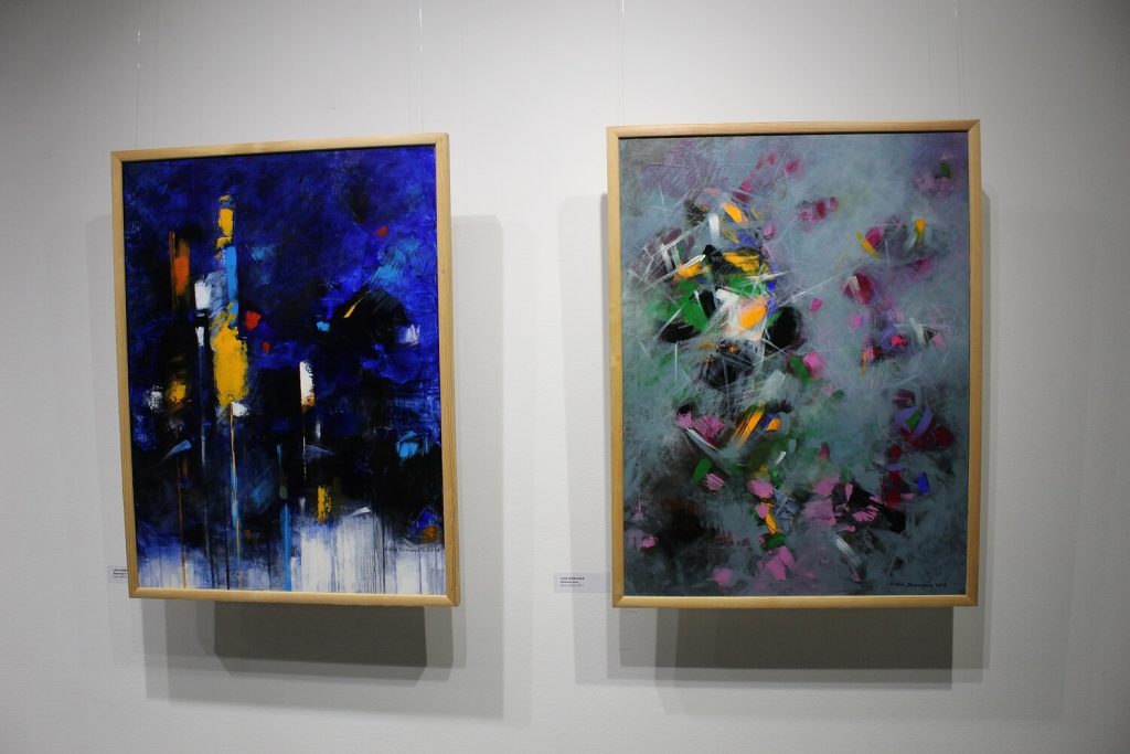 Dwa obrazy na ścianie sali GSW w trakcie wystawy Trzy Światy