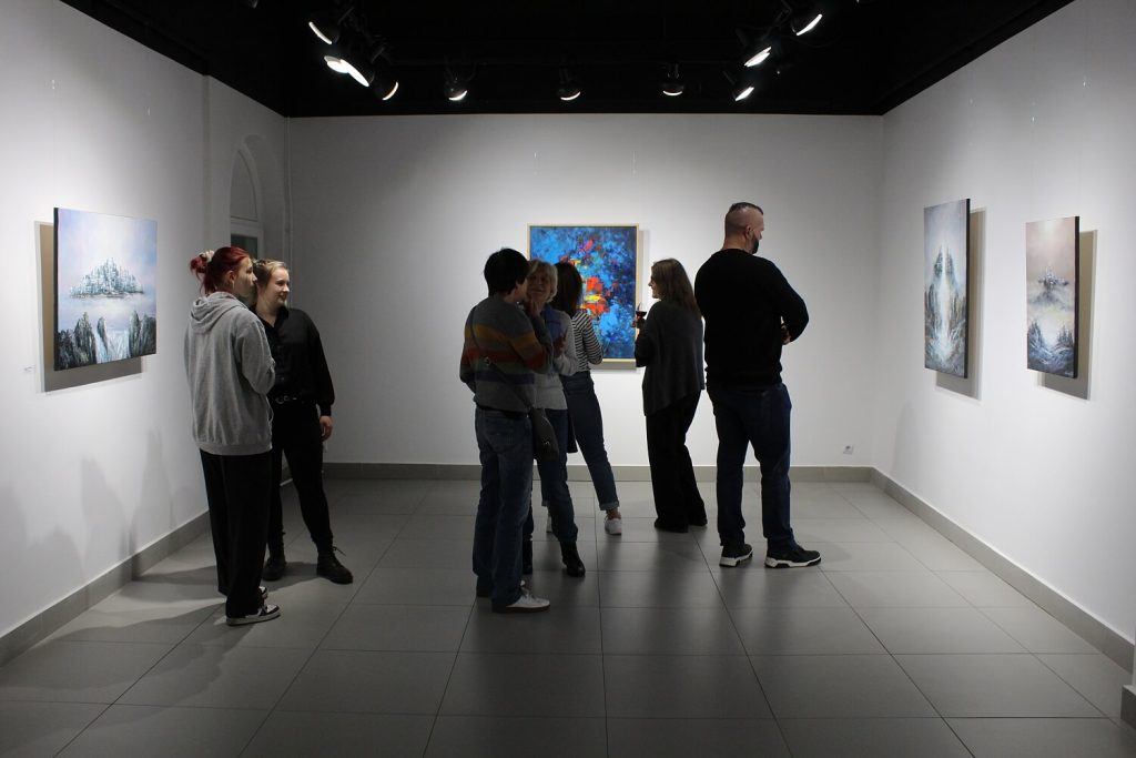 Uczestnicy wystawy oglądają obrazy