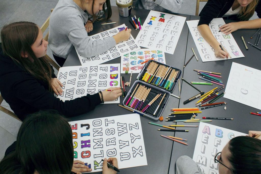 Dziewczynki kolorują litery alfabetu