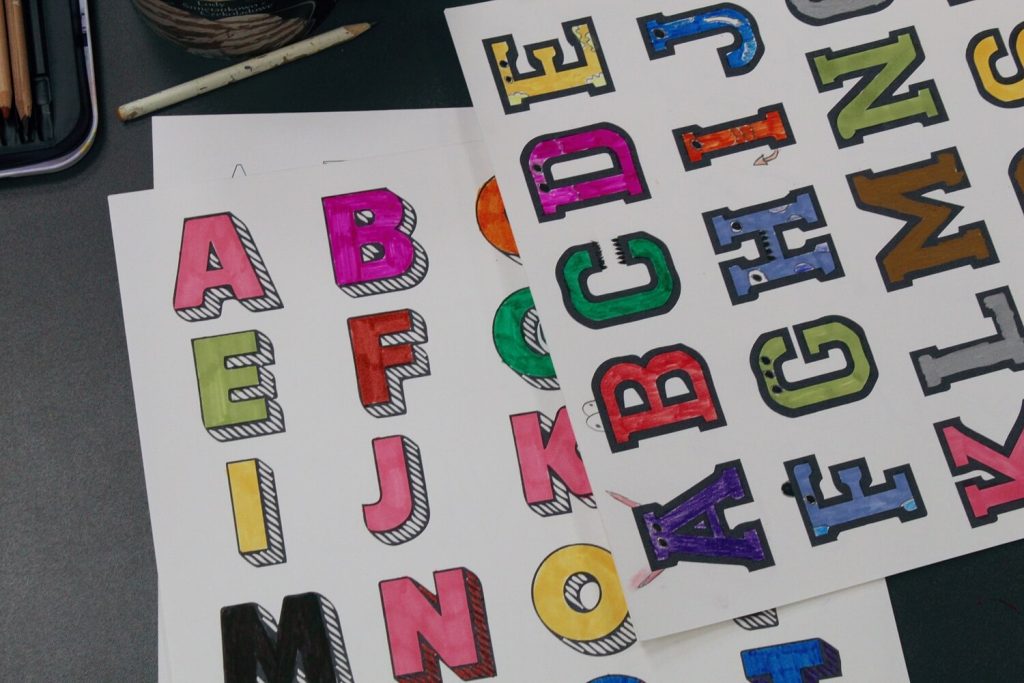 Pokolorowane przez dzieci grafiki z literami alfabetu