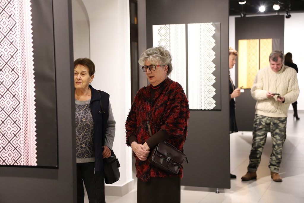 Dwie kobiety w trakcie zwiedzania wystawy Laury Dyczko w tle inni uczestnicy