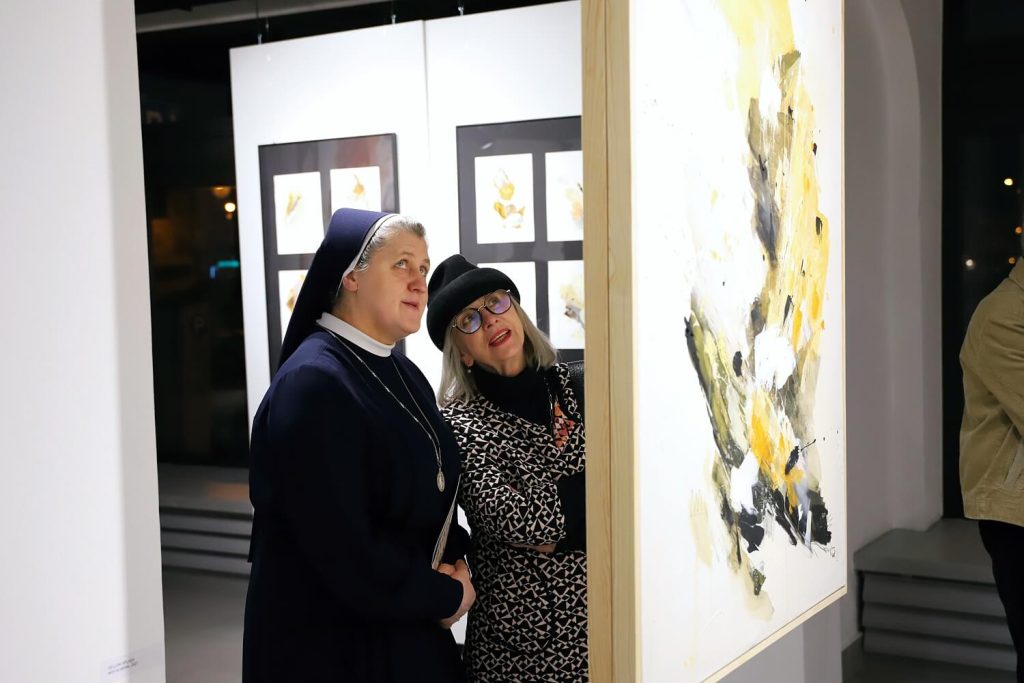 Siostra zakonna wraz z kobietą oglądająca obraz Katarzyny Kręcickiej