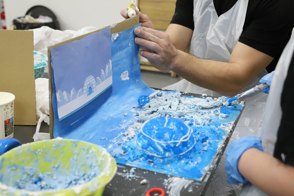 Malowanie pejzażu z gliny niebieską farbą