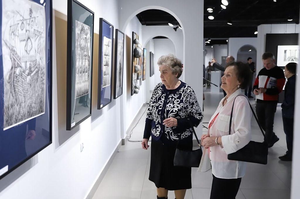 Kobiety zwiedzające wystawę obrazów Wojciecha Akuszewskiego