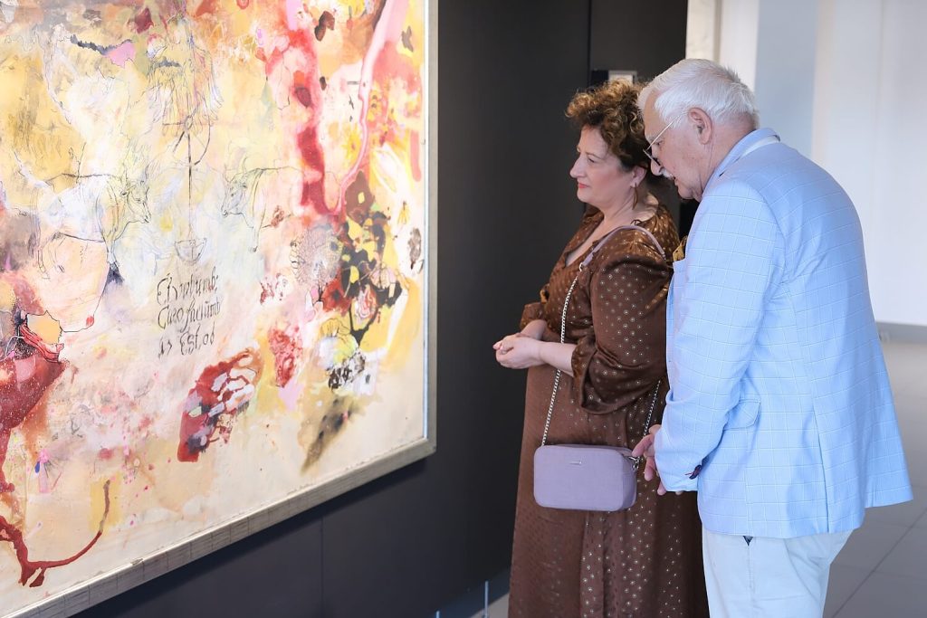 Mężczyzna z kobietą oglądają obraz autorstwa Malwiny Bienias