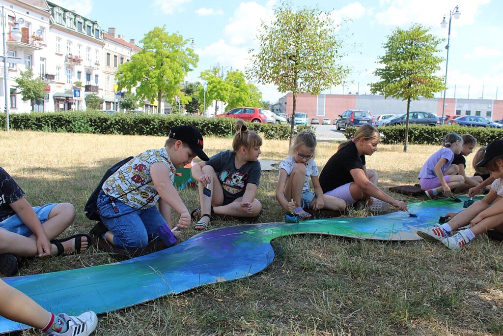 Dzieci malują wyciętą z kartonu rzekę