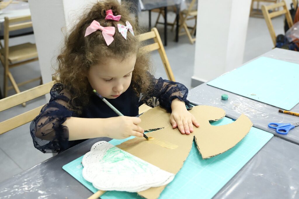 dziewczynka maluje farbrami suknie anioła