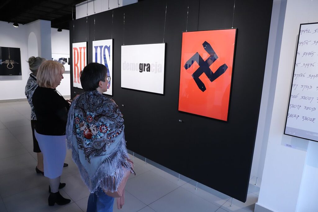 zwiedzający wystawę w przestrzeni dużej sali wystawowej